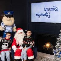 Brothers in black sweaters pose with Santa and Louie